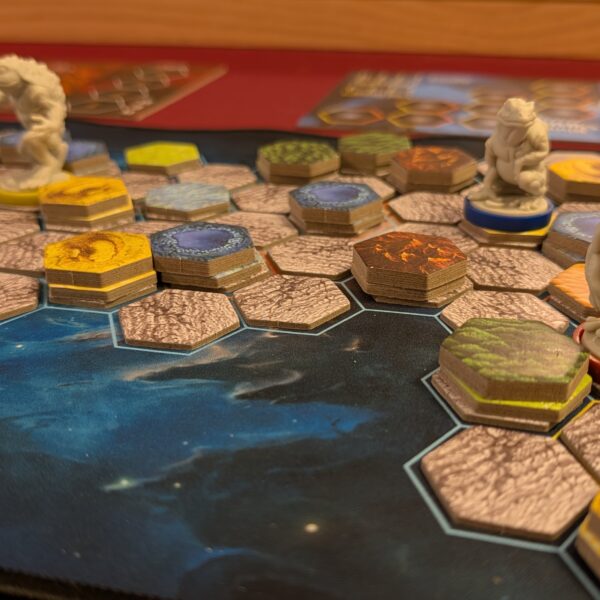 Close-up of Cosmic Frog setup with hexagonal land tiles and frog miniatures