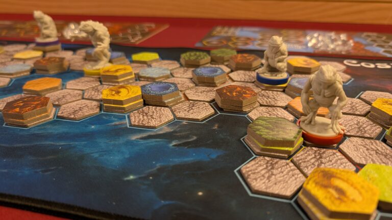 Close-up of Cosmic Frog setup with hexagonal land tiles and frog miniatures