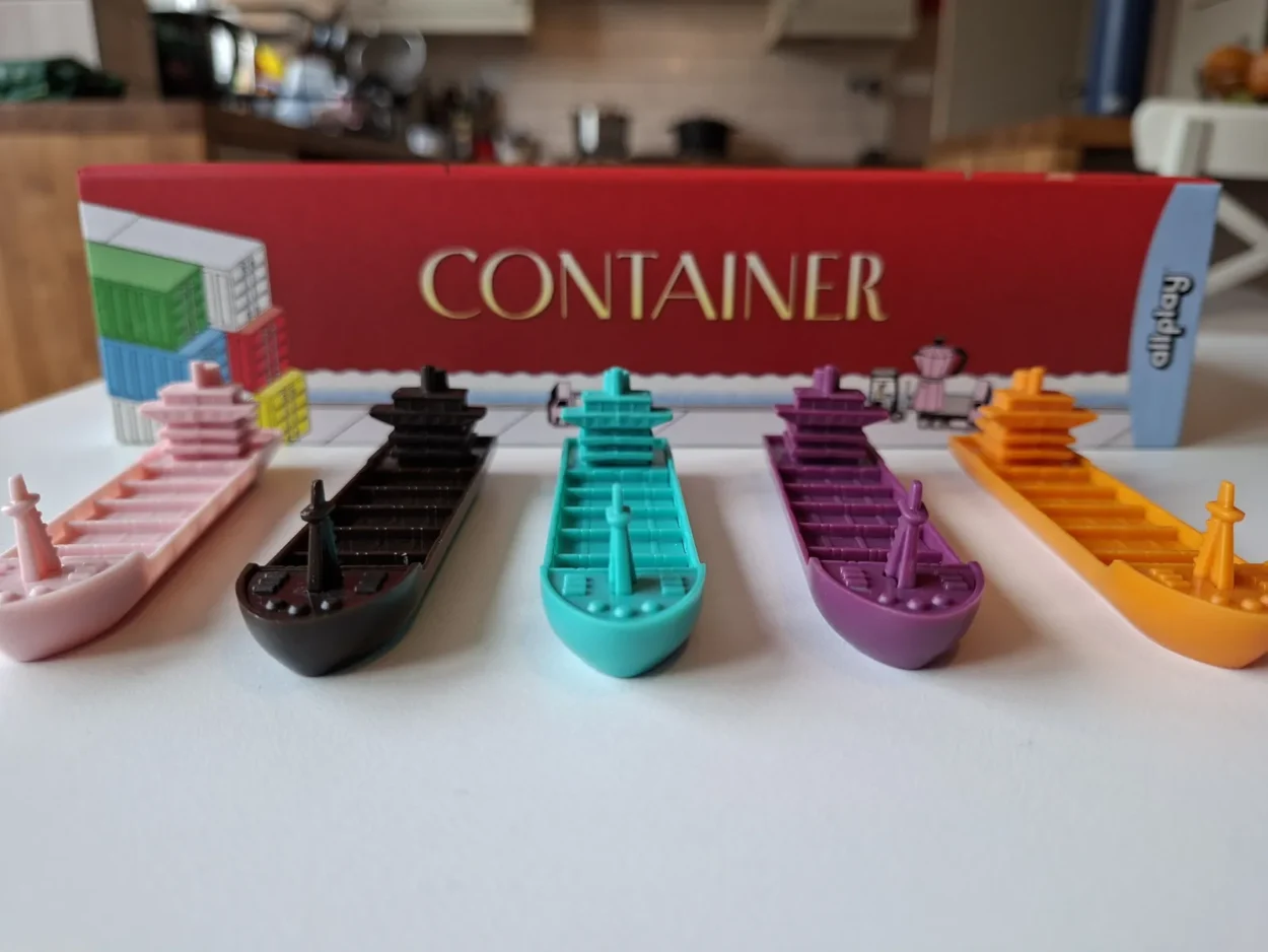 container ships in pink, black, teal, purple, and orange